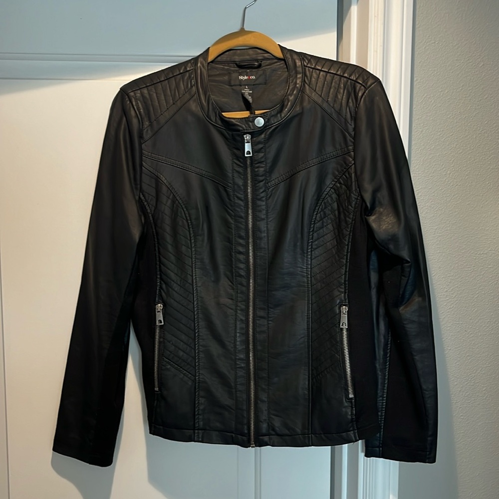 Black jacket side pockets zip up snap at the top